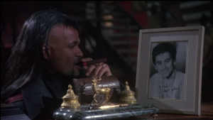 Why in the world does Macleod have his son's autographed headshot on his desk?